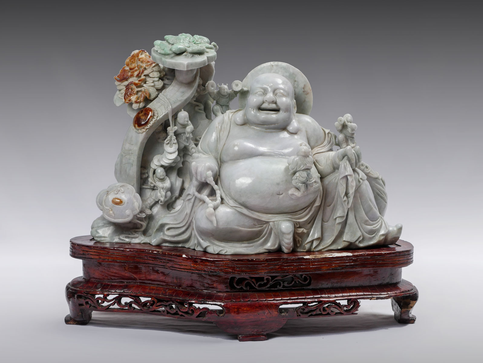 Appraisal: CARVED JADE SEATED HAPPY BUDDHA Happy sitting Buddha surrounded by