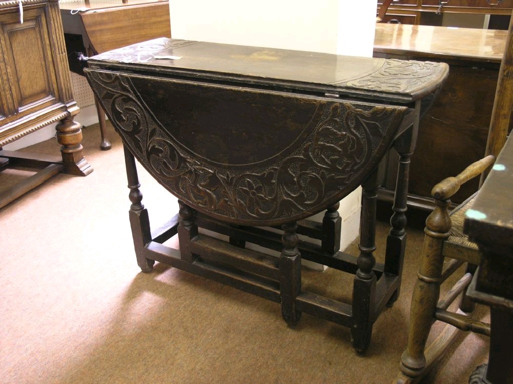 Appraisal: An th century oak gate-leg table the top later-carved with