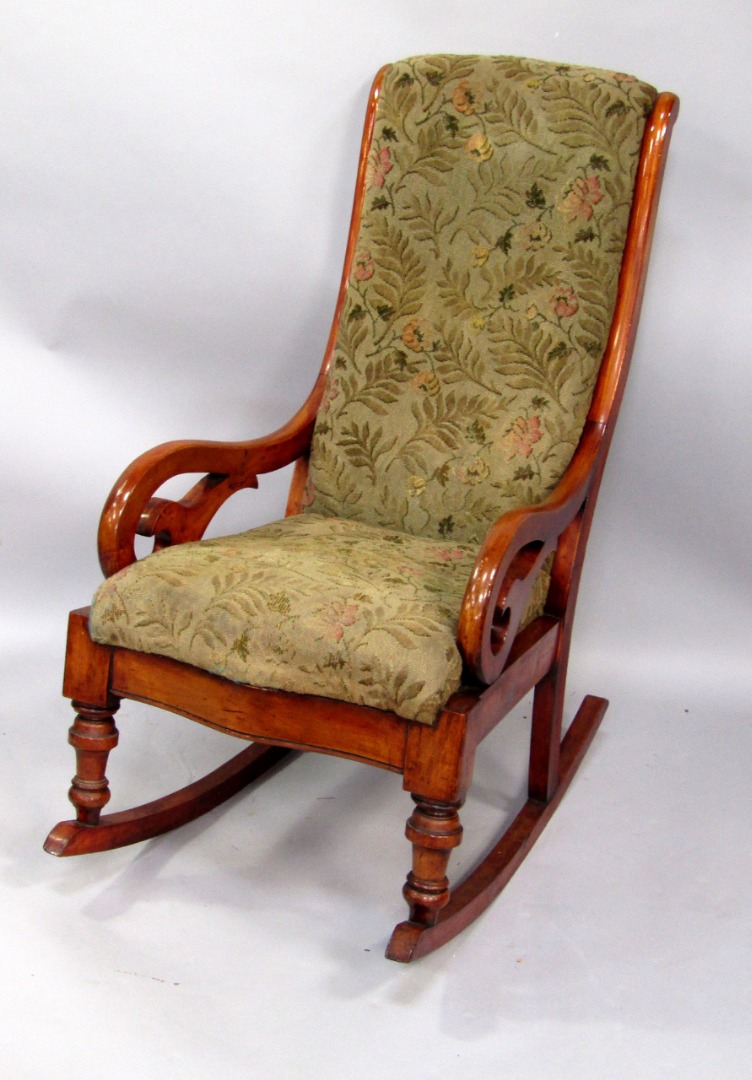 Appraisal: A thC mahogany rocking chair with a padded back and