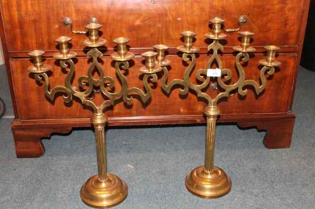 Appraisal: A PAIR OF FIVE BRANCH BRASS CANDELABRA with pierced decoration