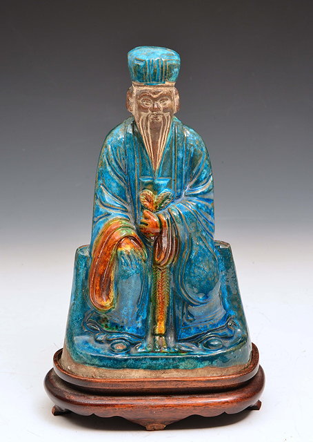 Appraisal: A CHINESE POTTERY FIGURE OF A SEATED IMMORTAL decorated with