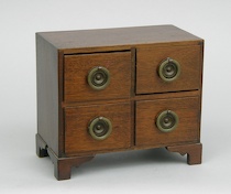 Appraisal: A Salesman's Sample Chest of Drawers A dark stained wooden