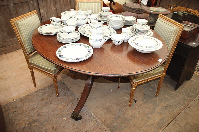 Appraisal: A GEORGIAN MAHOGANY OVAL TILT TOP DINING TABLE with turned