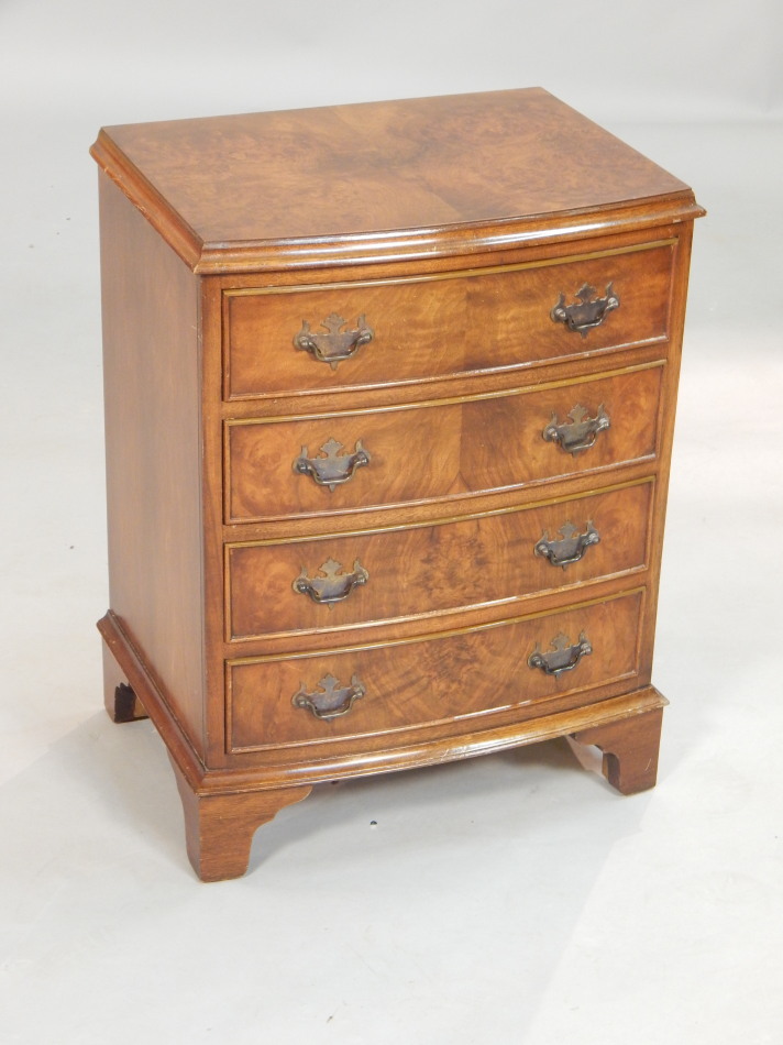 Appraisal: A Reprodux walnut veneered small bow fronted chest of four