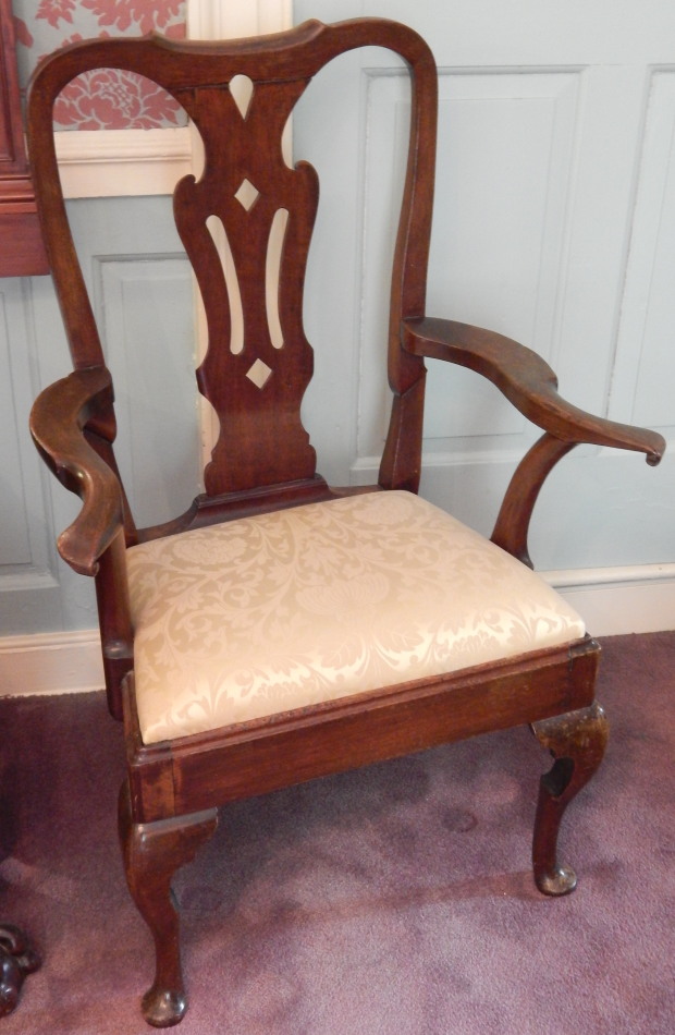 Appraisal: A walnut open arm chair with a pierced splat scroll