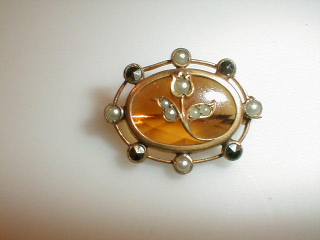 Appraisal: An Edwardian brooch with central yellow stone set atop with