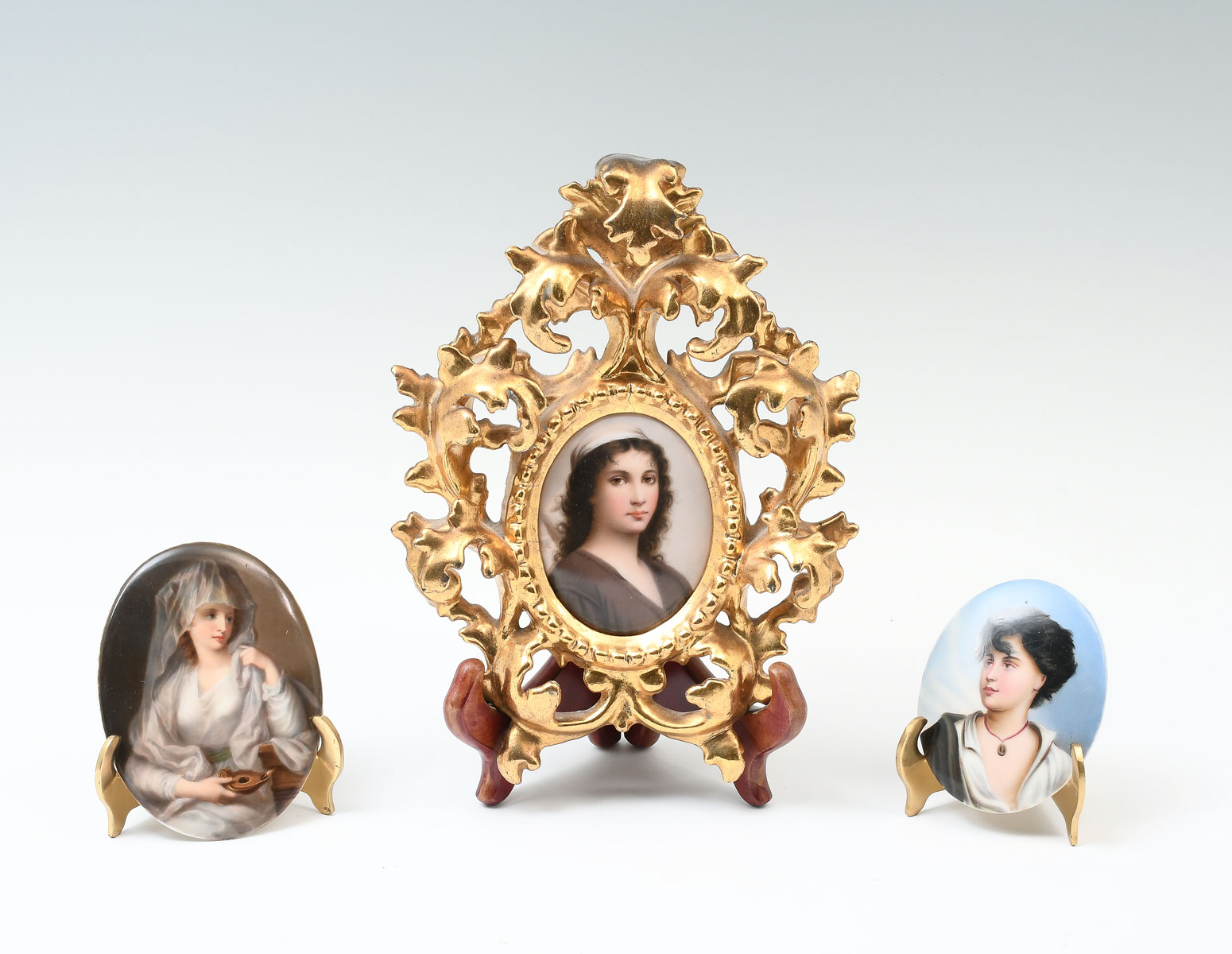 Appraisal: THREE MINIATURE PORCELAIN PAINTINGS An Oval Portrait of a Young