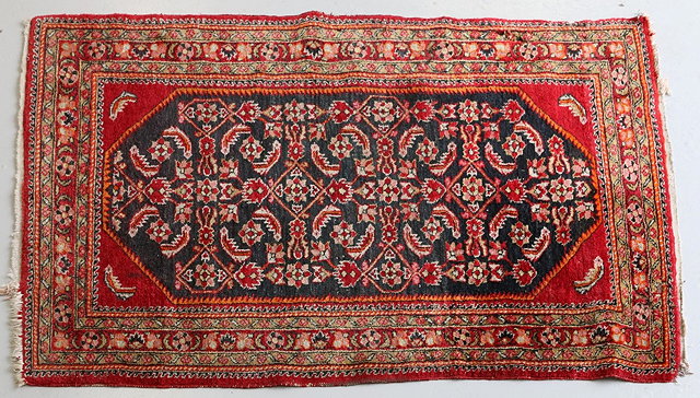 Appraisal: A HAMADAN DARK BLUE GROUND RUG with red and orange