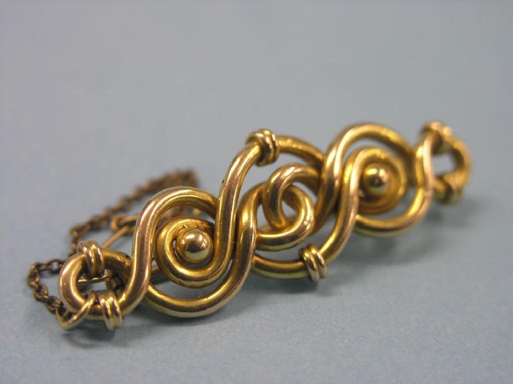 Appraisal: A yellow metal bar brooch Celtic scroll form unmarked grams