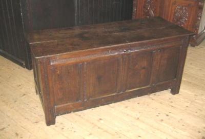 Appraisal: AN OAK PANELLED COFFER with hinged plank lid the fascia