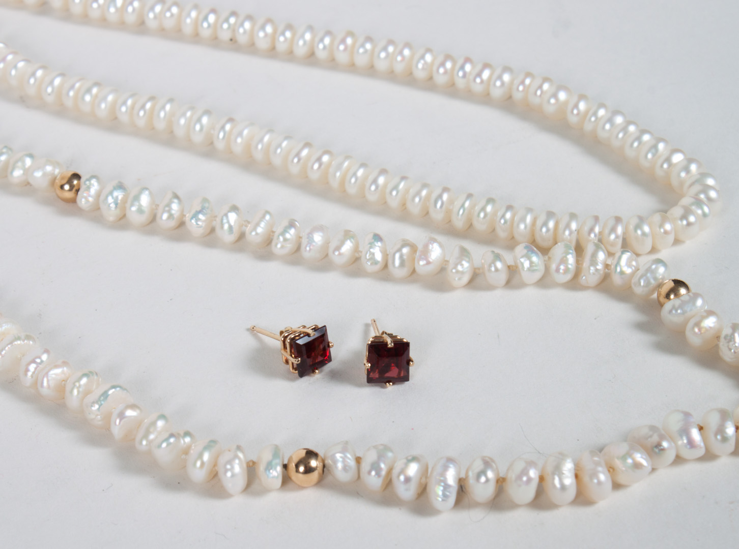 Appraisal: Two pearl necklaces pair of garnet stud earrings baroque pearls