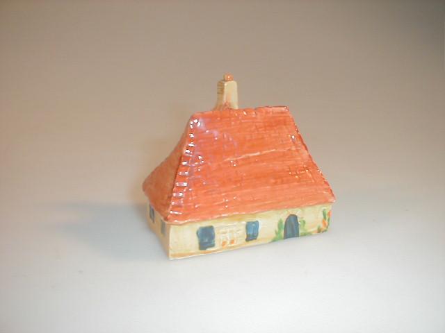 Appraisal: A pottery cottage with an orange roof and blue doors