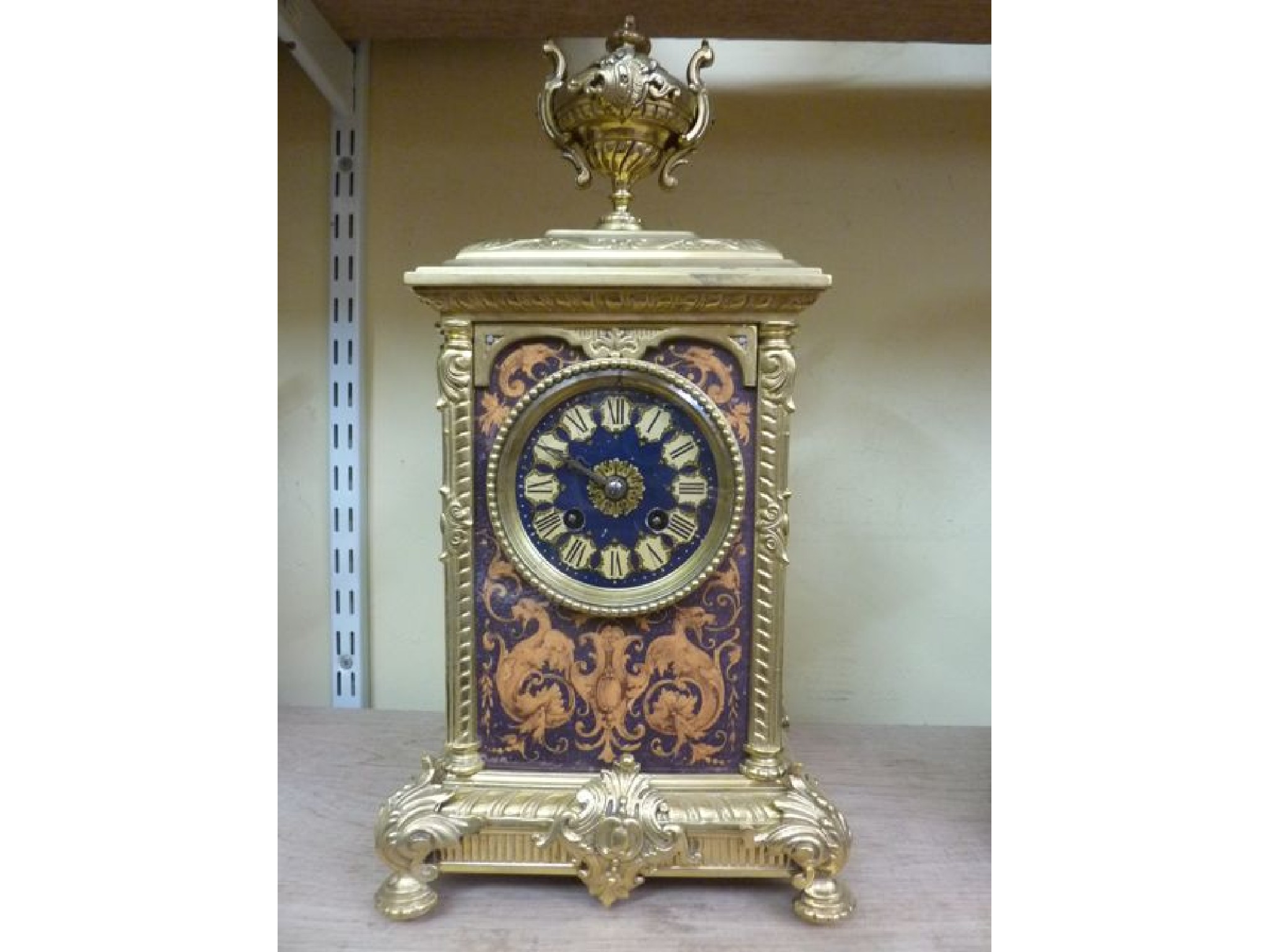 Appraisal: A brass cased mantle clock with cast detail set beneath