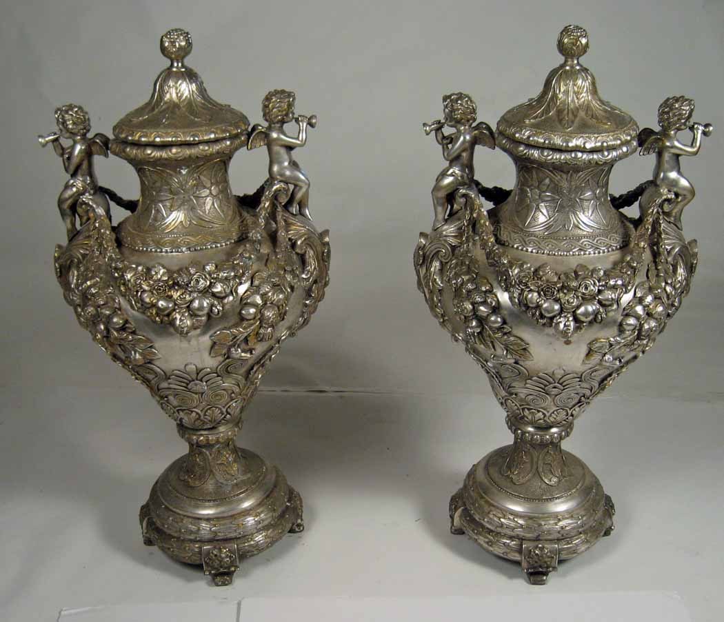 Appraisal: Pair of baroque style silvered metal urns Each cover with