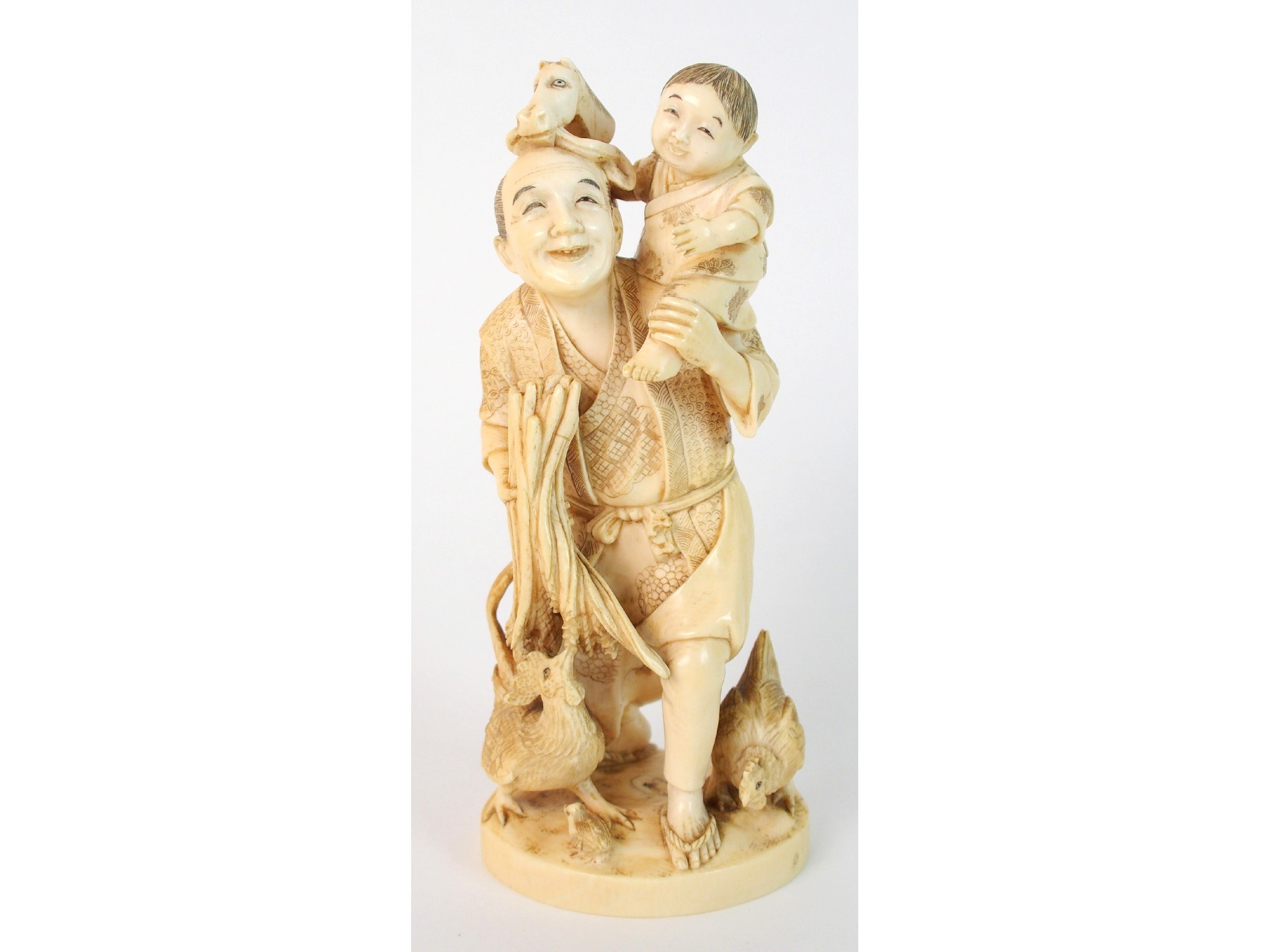 Appraisal: A Japanese ivory okimono of a manstanding with a child