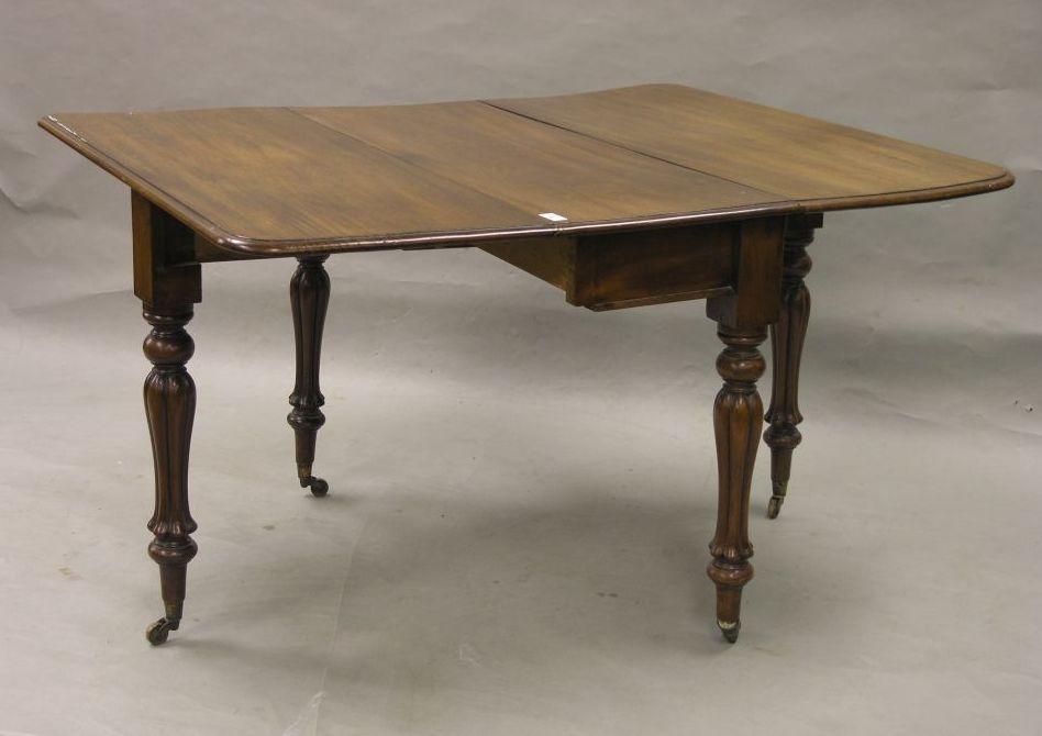 Appraisal: A Victorian mahogany drop leaf dining table on bulbous reeded