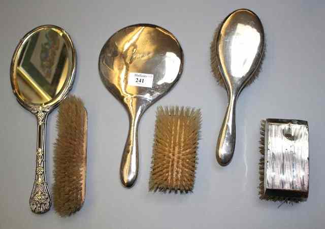 Appraisal: A SILVER HAND MIRROR with two matching brushes two silver