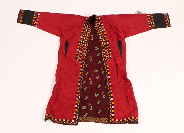 Appraisal: A TURKOMAN CRIMSON SILK EMBROIDERED CHAPAN ROBE with stylised hooked