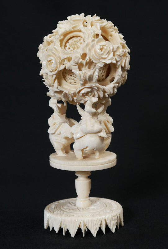 Appraisal: CARVED IVORY MYSTERY BALL AND STAND Floral motif carved mystery