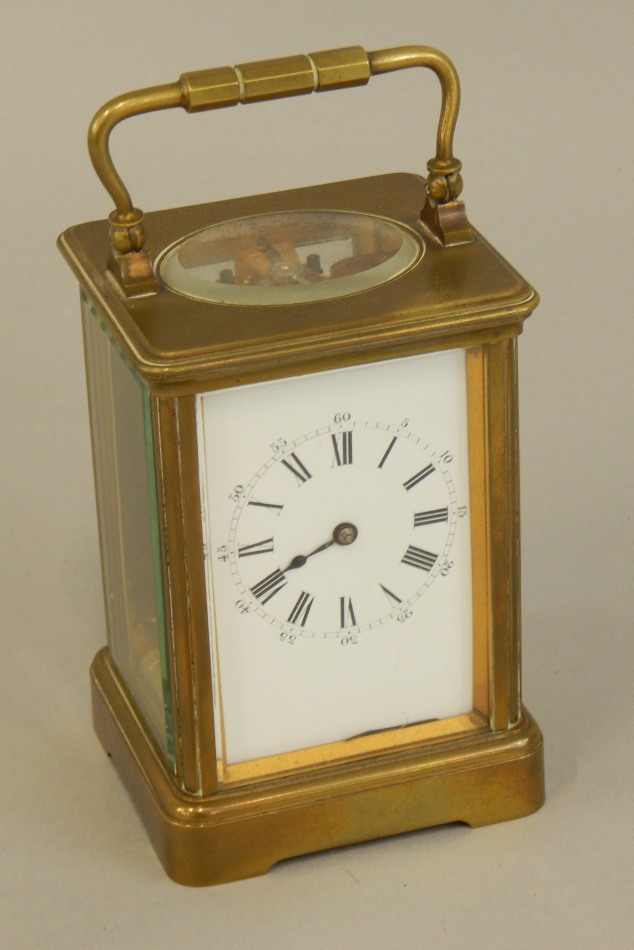 Appraisal: A French brass carriage timepiece the white enamel dial with