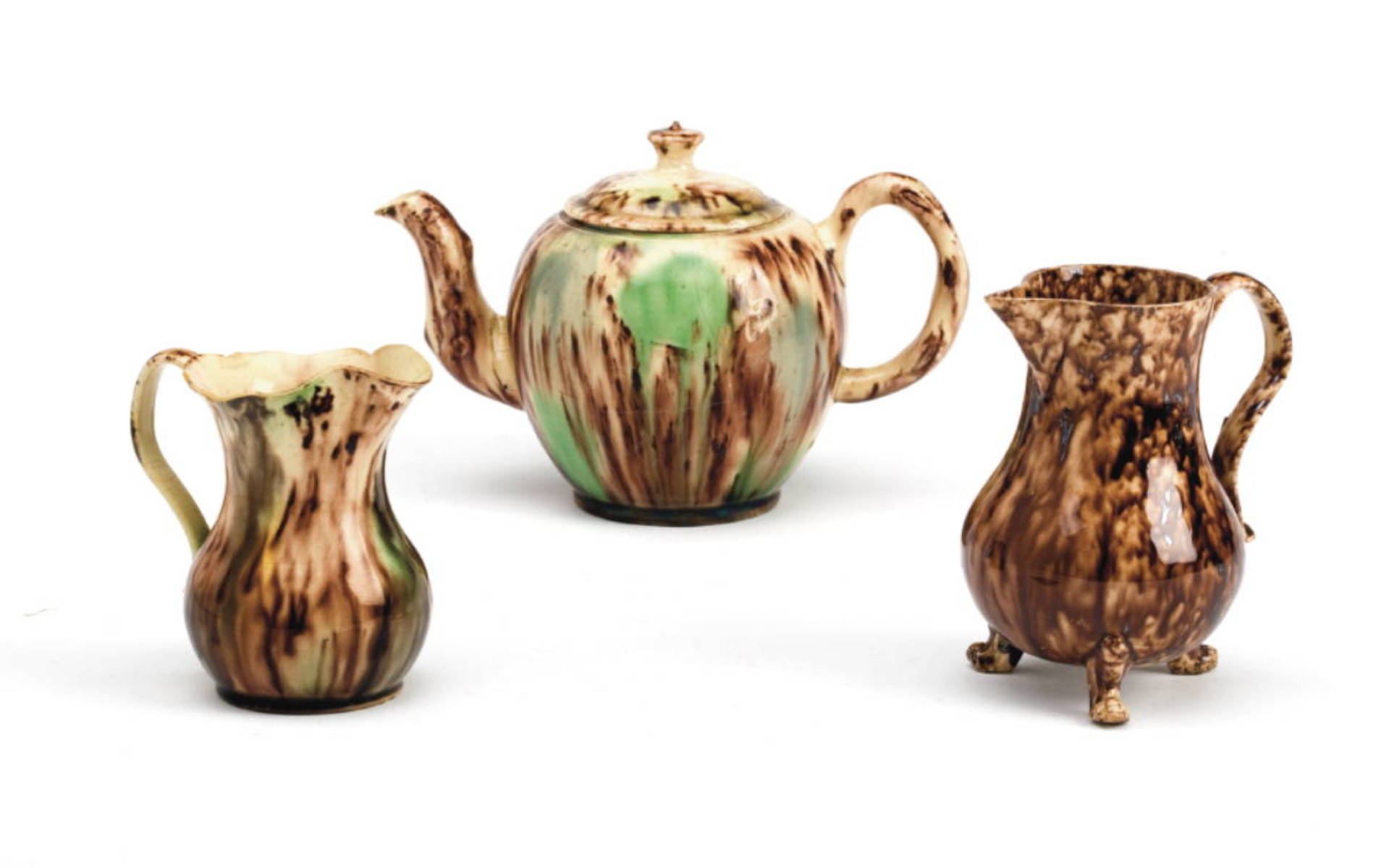 Appraisal: THREE STAFFORDSHIRE CREAMWARE TORTOISESHELL-GLAZED WARES CIRCA - Comprising a teapot