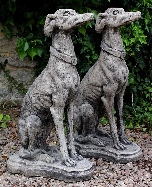 Appraisal: A PAIR OF CAST COMPOSITE STONE SEATED GREYHOUNDS each wearing