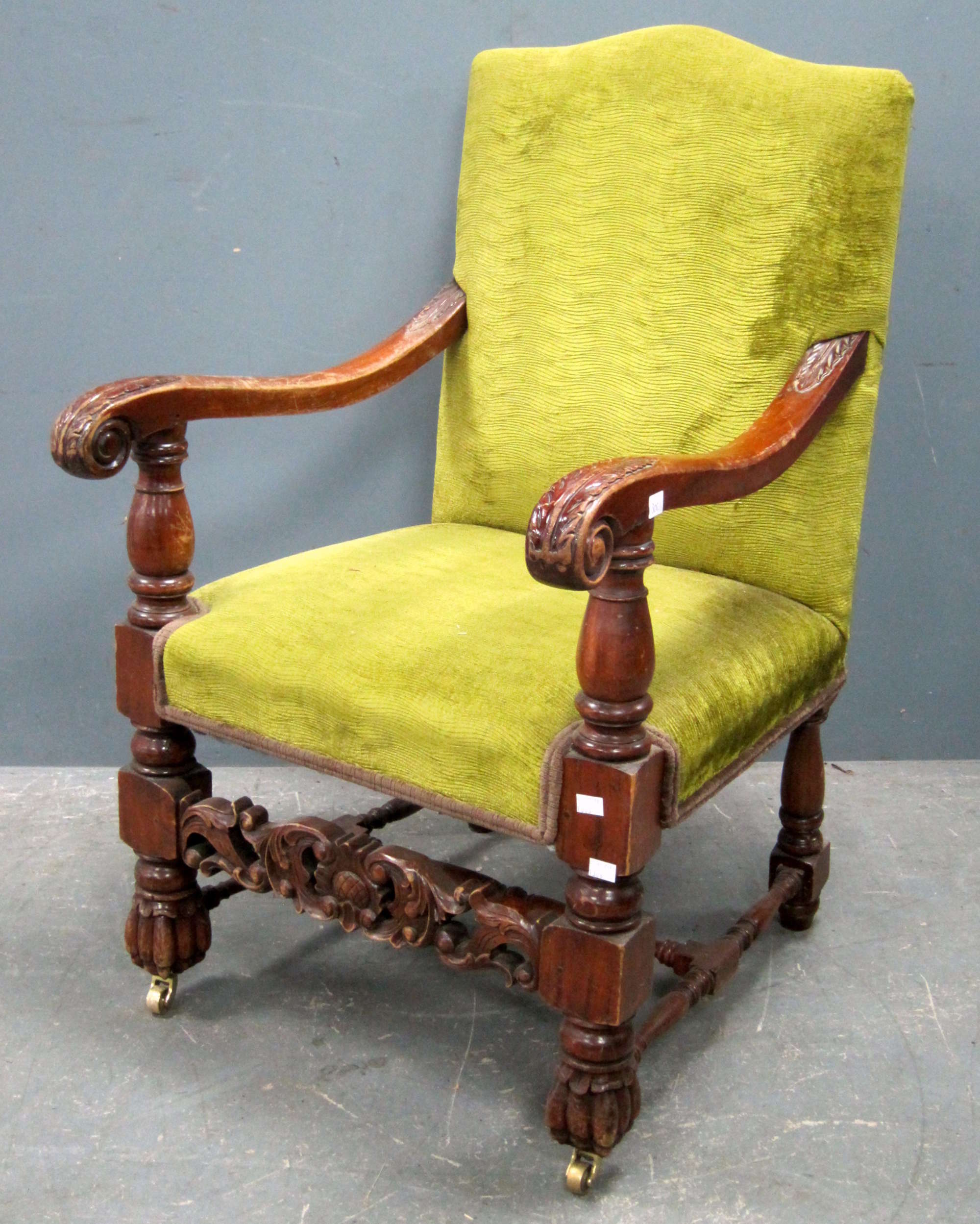 Appraisal: A carved wood and upholstered armchair with leaf capped arms