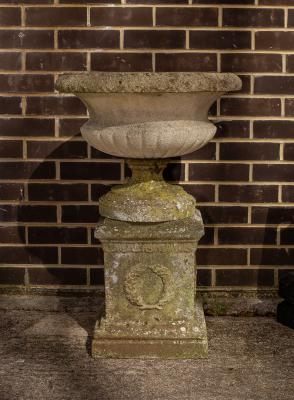 Appraisal: A reconstituted stone garden vase with reeded base on a