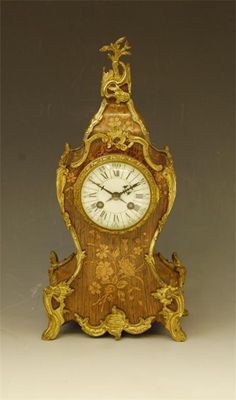 Appraisal: A French rosewood and floral marquetry cartouche shape mantel clock