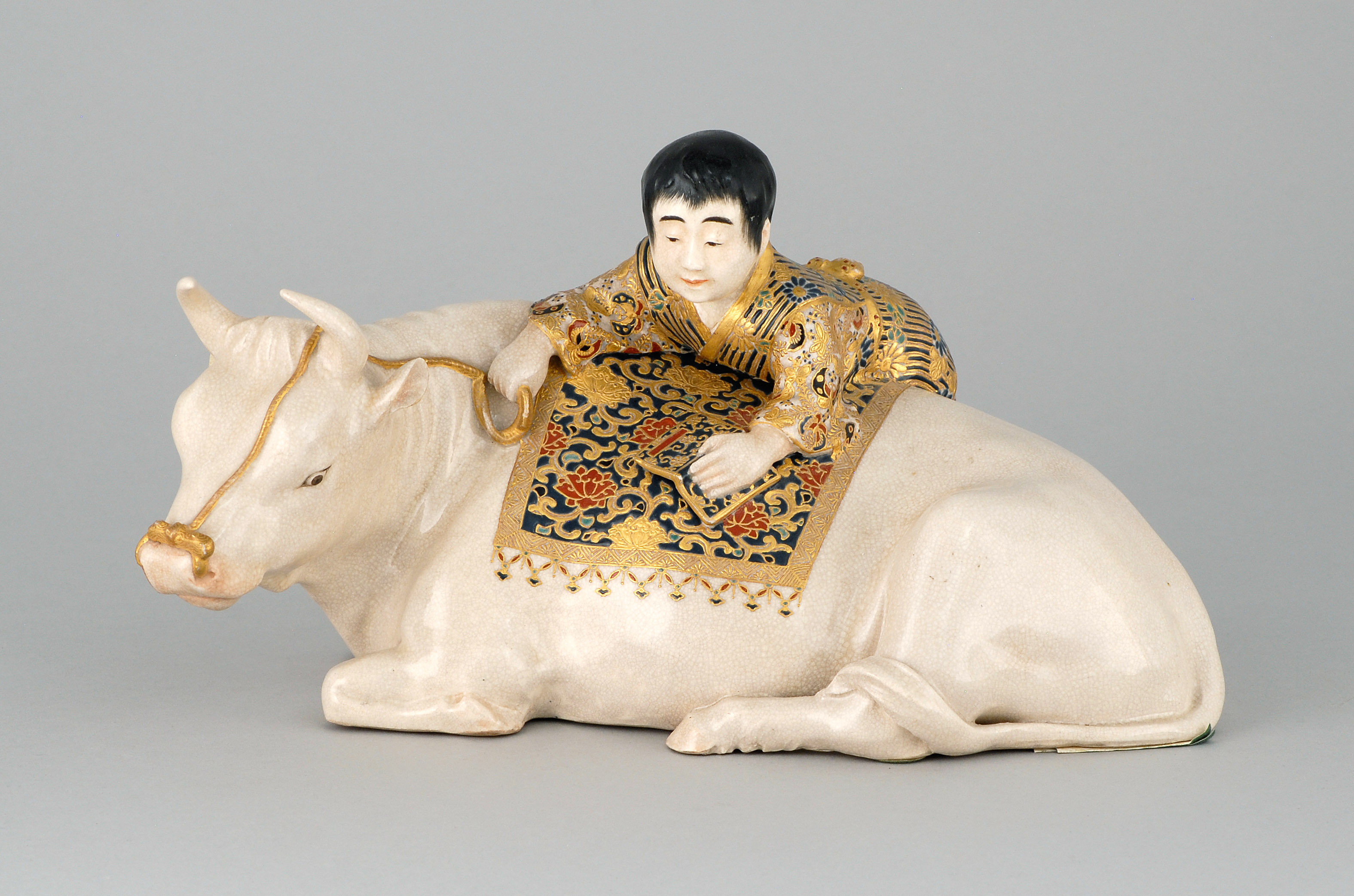 Appraisal: SATSUMA POTTERY SCULPTURE Circa Depicting a youth holding a book