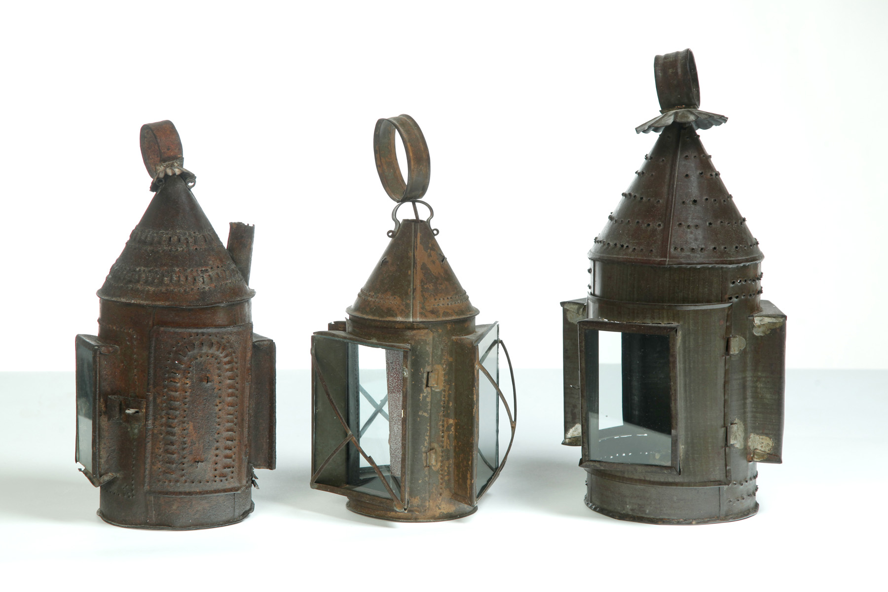 Appraisal: THREE AMERICAN PUNCHED TIN LANTERNS Nineteenth century All have panes