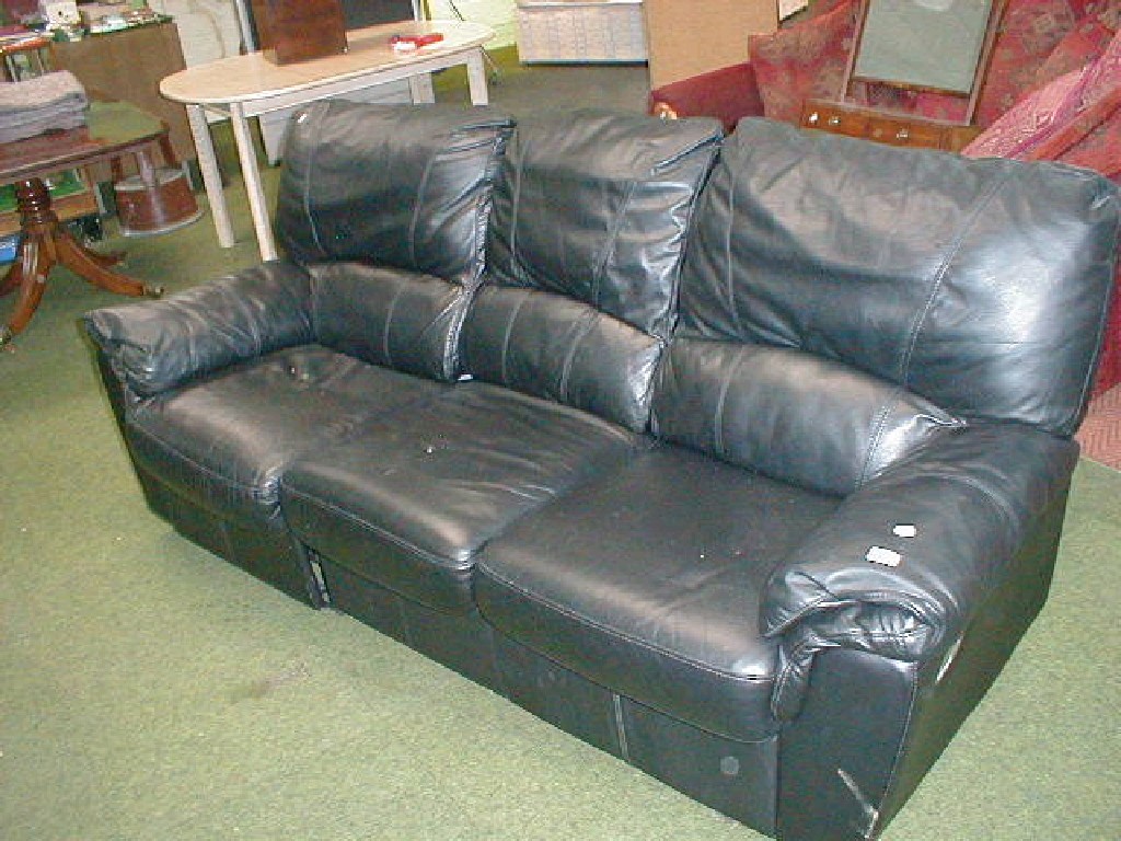 Appraisal: A black leather finished reclining three seater sofa