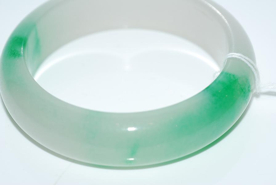 Appraisal: A JADE BANGLE IN GREEN AND LAVENDER HUES A JADE