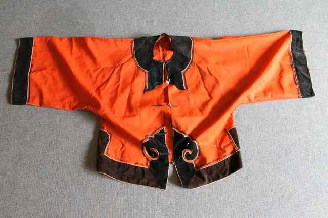 Appraisal: A CHINESE MANDARIN STYLE JACKET orange with black velvet trim