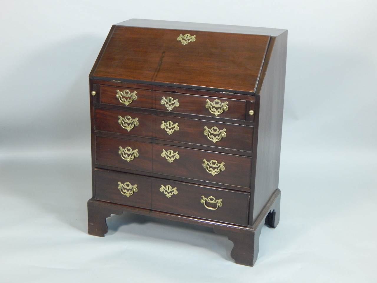 Appraisal: A George III red walnut bureau of small proportions the