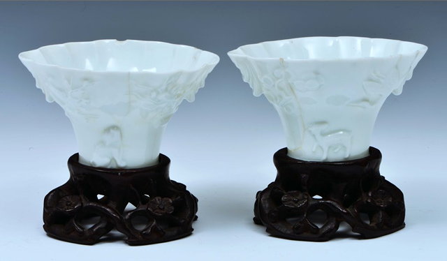 Appraisal: A PAIR OF DE HUA LIBATION CUPS moulded dragons deer