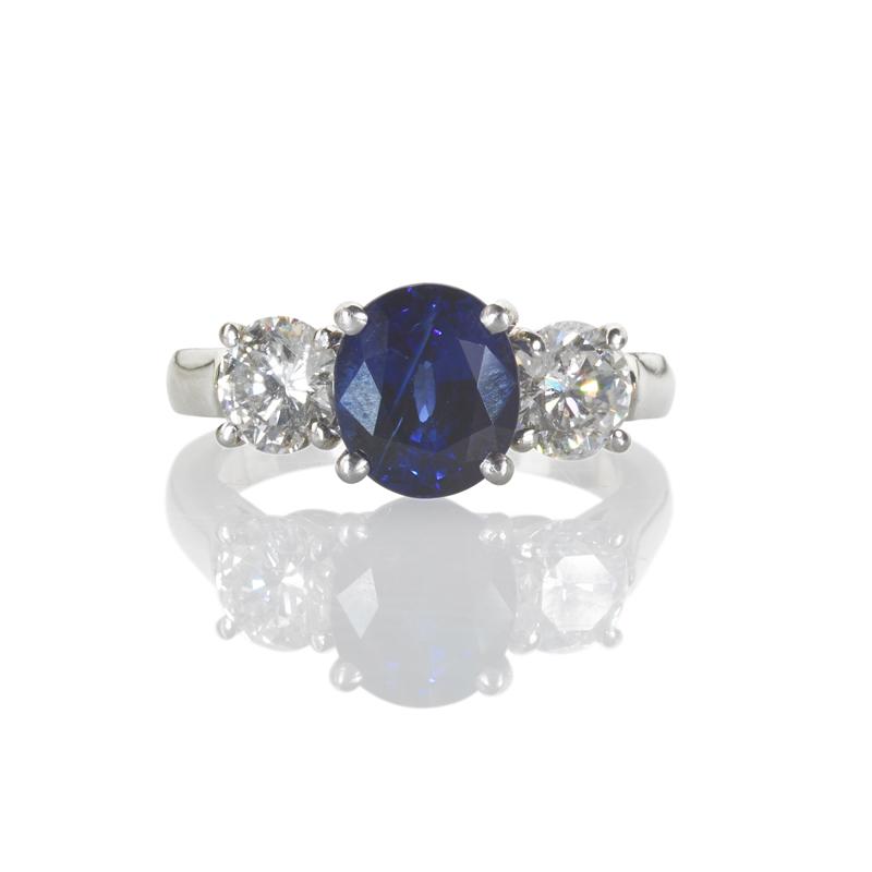 Appraisal: SAPPHIRE AND DIAMOND PLATINUM THREE-STONE RING Oval faceted blue sapphire