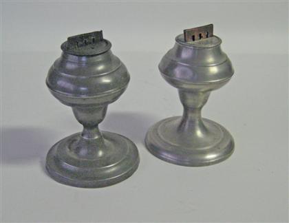 Appraisal: Two pewter lard lamps Each with molded urn-form H in