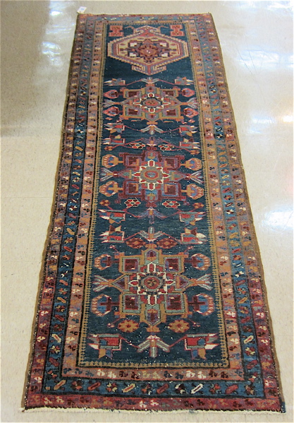 Appraisal: SEMI-ANTIQUE PERSIAN TRIBAL AREA RUG featuring four geometric Kazak medallions