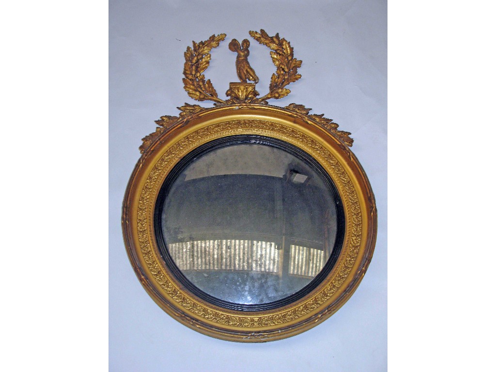 Appraisal: A Regency convex circular wall mirror surmounted by a cherub