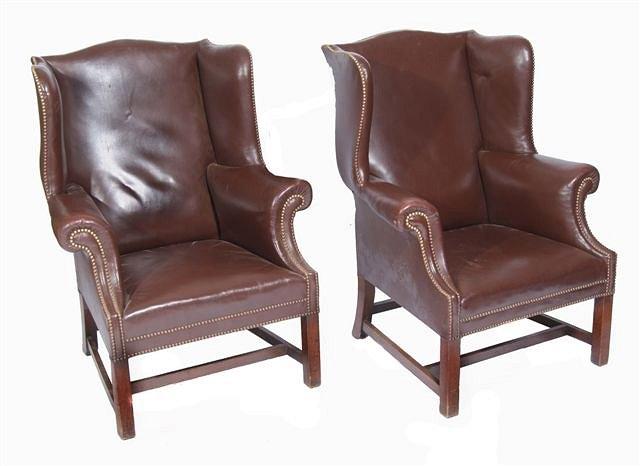 Appraisal: A pair of leather upholstered wing back armchairs on square