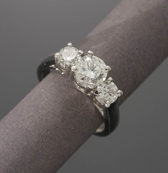 Appraisal: -Karat White-Gold and Three-Diamond Ring Centered with one round brilliant-cut