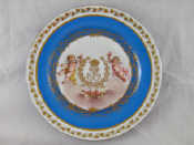 Appraisal: A Sevres cake plate the centre cherubs either side of