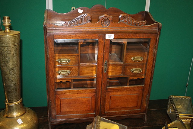 Appraisal: AN EDWARDIAN OAK SMOKER'S CABINET the interior fitted with small