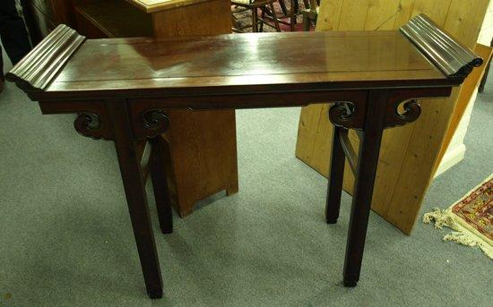 Appraisal: An Oriental hardwood table with scroll ends raised on moulded