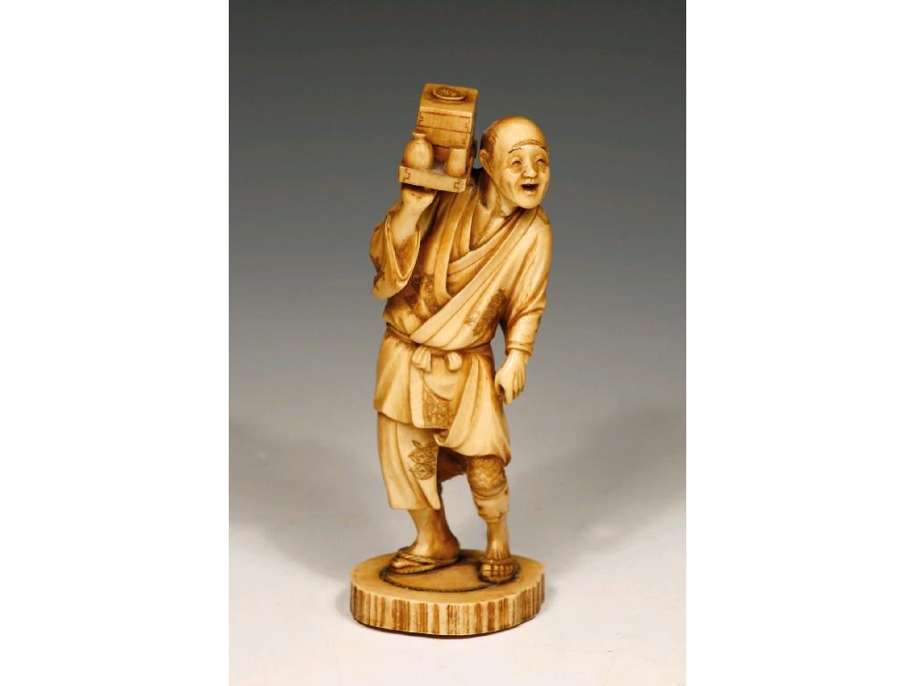 Appraisal: A JAPANESE STAINED-IVORY OKIMONO of a man holding a food