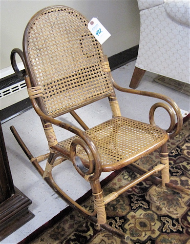 Appraisal: CHILD'S WICKER AND RATTAN ROCKING CHAIR the scrolling rattan frame