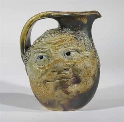 Appraisal: A Martin Brothers stoneware face jug each side modelled with