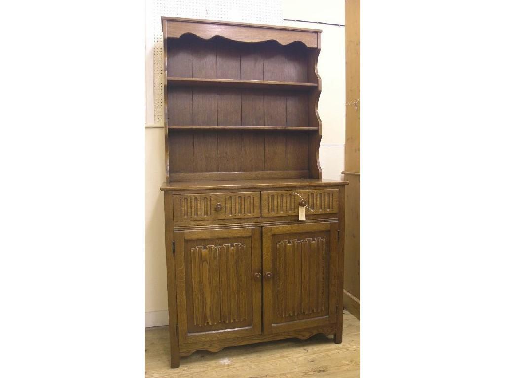 Appraisal: A medium oak Welsh dresser twin-shelf plate rack above linenfold