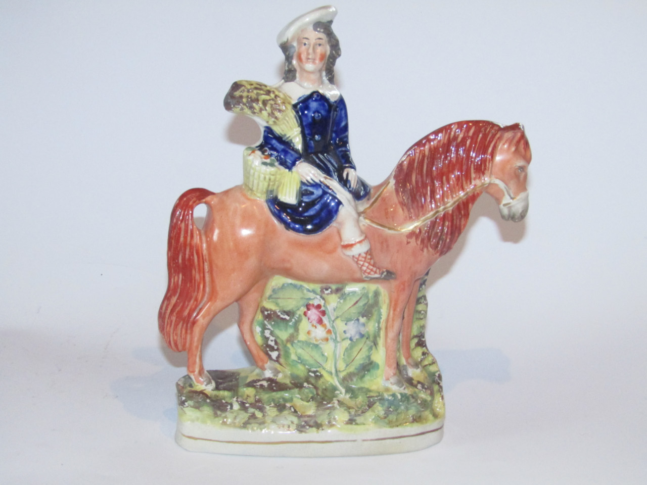 Appraisal: A thC Staffordshire equestrian group the figure holding wheatsheaf and